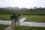 Three officers stand ready as a class member fires an M-16.